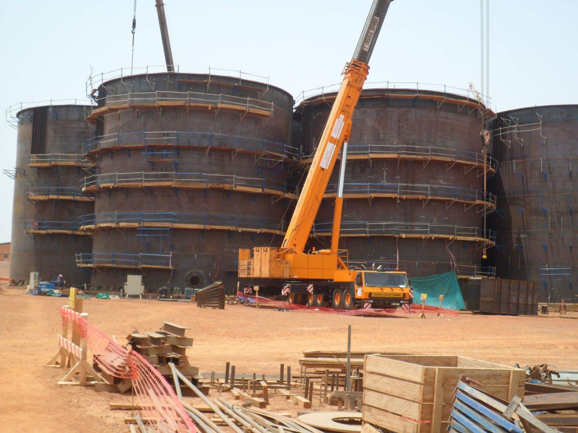Grues érigeant des réservoirs de stockage industriels